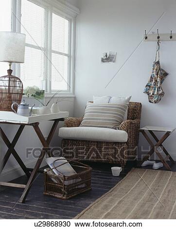 Folding tray-table and wicker sofa in white coastal living room View Large Photo Image Stock Image - Folding tray-table and wicker sofa in white coastal living room. Fotosearch