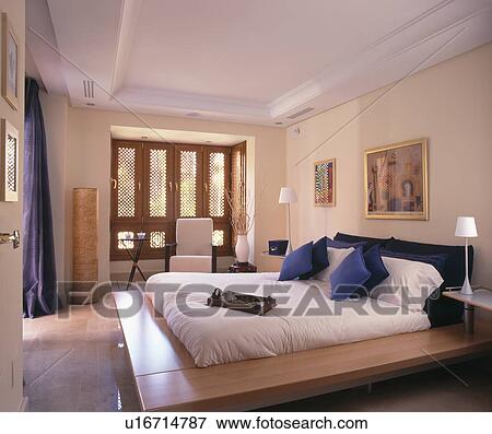 Stock Photo - Futon on low platform in modern Spanish bedroom. Fotosearch