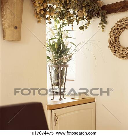 Hops on beam above white lilies in glass vase on concealed freezer View Large Photo Image Stock Photography - Hops on beam above white lilies in glass vase on concealed freezer. Fotosearch