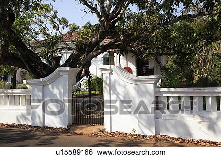 Stock Photograph - Iron gate in white wall around private villa.. Fotosearch