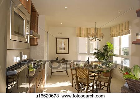 Stock Image - Kitchen with small dining table and chairs.. Fotosearch