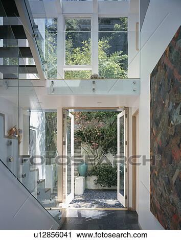 Large double height modern hall with view of garden through open glass door View Large Photo Image Stock Image - Large double height modern hall with view of garden through open glass door. Fotosearch