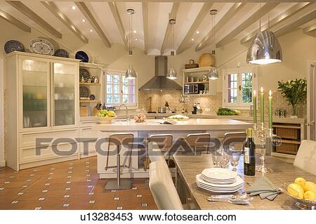 Large openplan kitchen diningroom with glass fronted cupboard, breakfast bar and diningtable View Large Photo Image Stock Image - Large openplan kitchen diningroom with glass fronted cupboard, breakfast bar and diningtable. Fotosearch