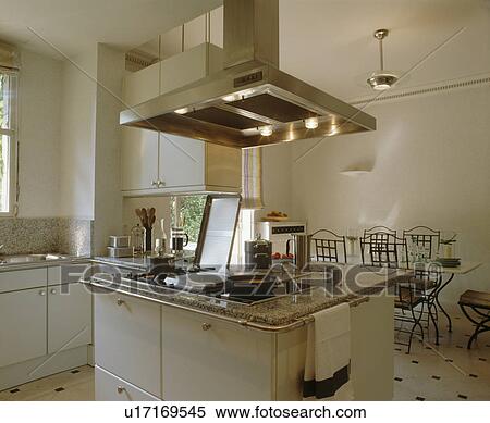 Lighted stainless steel extractor above hob in island unit in modern white kitchen dining room View Large Photo Image Stock Photography - Lighted stainless steel extractor above hob in island unit in modern white kitchen dining room. Fotosearch