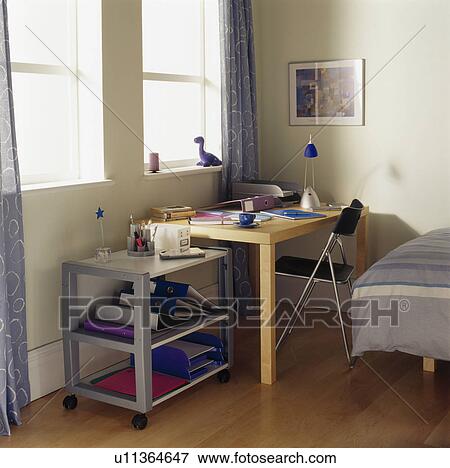 Metal trolley and small desk and chair in study area of child's modern bedroom View Large Photo Image Stock Photo - Metal trolley and small desk and chair in study area of child's modern bedroom. Fotosearch