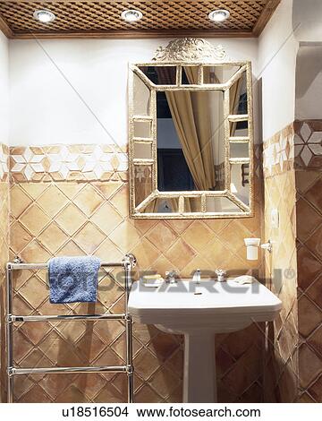 Picture - Mirror above basin in tiled Mediterranean bathroom. Fotosearch