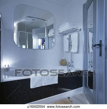 Mirror above bath with black surround in modern white bathroom View Large Photo Image Picture - Mirror above bath with black surround in modern white bathroom. Fotosearch