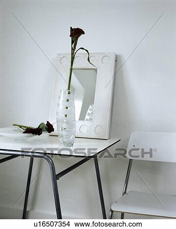 Picture - Mirror and glass vase on white trestle table in modern white dining room. Fotosearch