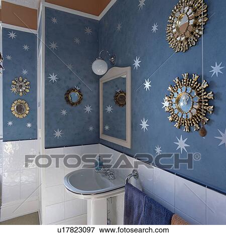 Ornate circular gilt mirrors in bathroom with blue wallpaper View Large Photo Image Stock Photo - Ornate circular gilt mirrors in bathroom with blue wallpaper. Fotosearch