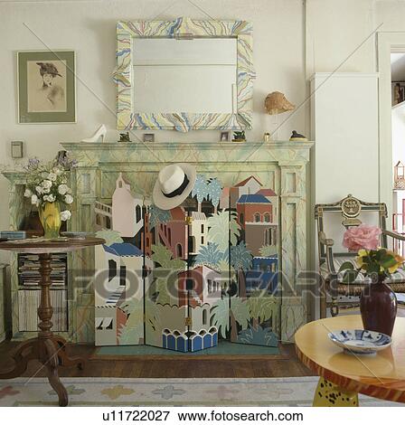 Stock Photo - Painted mural on small folding screen in front of decorated fireplace and mirror. Fotosearch