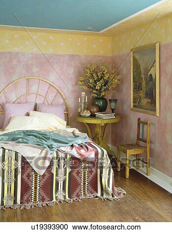Painted pink and yellow walls in ethnic-style bedroom with Kelim throw on bed View Large Photo Image Stock Image - Painted pink and yellow walls in ethnic-style bedroom with Kelim throw on bed. Fotosearch
