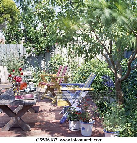 Painted wooden chairs and table on decked patio in Californian garden View Large Photo Image Stock Photo - Painted wooden chairs and table on decked patio in Californian garden. Fotosearch