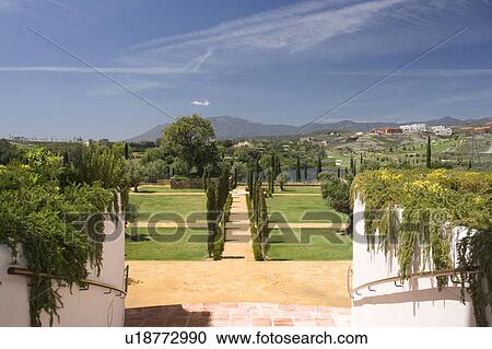 Stock Image - Pathway through newly planted cypress to golf course and lake.. Fotosearch