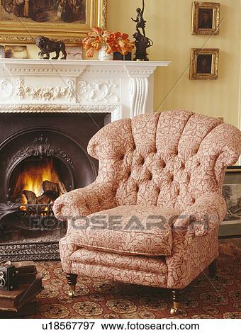 Peach armchair beside fireplace in traditional living room View Large Photo Image Stock Photo - Peach armchair beside fireplace in traditional living room. Fotosearch