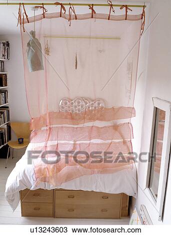 Peach voile curtain screening single bed View Large Photo Image Stock Image - Peach voile curtain screening single bed. Fotosearch