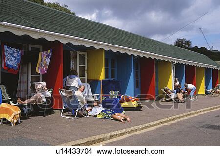 People enjoying leisure time outside colourful beach huts in Bournemouth in Hampshire View Large Photo Image Picture - People enjoying leisure time outside colourful beach huts in Bournemouth in Hampshire. Fotosearch