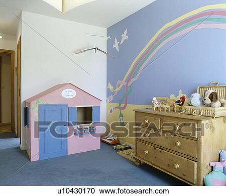Pink and blue playhouse in playroom with rainbow mural and pine chest-of-drawers View Large Photo Image Stock Image - Pink and blue playhouse in playroom with rainbow mural and pine chest-of-drawers. Fotosearch