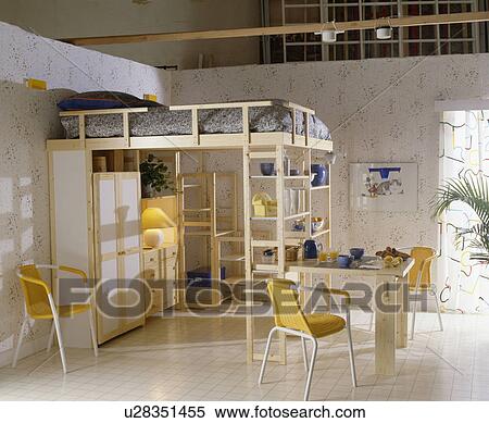 Platform bed on fitted wooden storage in study bedroom with yellow chairs and white flooring View Large Photo Image Stock Photography - Platform bed on fitted wooden storage in study bedroom with yellow chairs and white flooring. Fotosearch