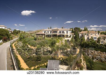 Stock Image - Recently constructed large villas with landscaped garden and solar heating panels.. Fotosearch