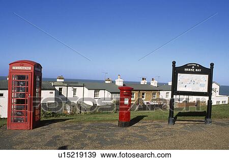 Stock Photo - REd British telephone box and postbox above row of cottages at Herne Bay in Kent. Fotosearch
