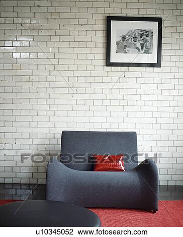 Red cushion on modern grey armchair against white ceramic brick wall View Large Photo Image Stock Image - Red cushion on modern grey armchair against white ceramic brick wall. Fotosearch