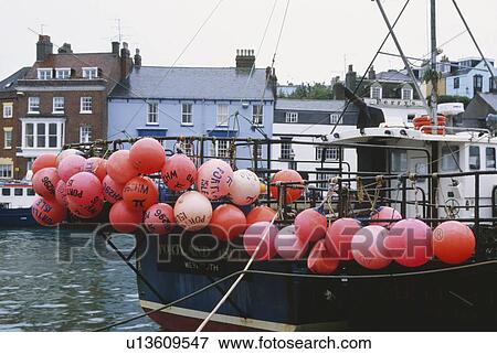 Stock Photo - Red floats on fishing boat in Swanage Harbour Dorset. Fotosearch