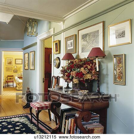 Red lamps and floral arrangement on console table in pastel blue hall View Large Photo Image Stock Photography - Red lamps and floral arrangement on console table in pastel blue hall. Fotosearch