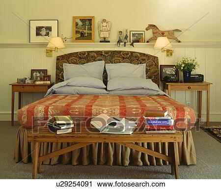 Rustic bench below bed with patterned red bedcover View Large Photo Image Stock Image - Rustic bench below bed with patterned red bedcover . Fotosearch