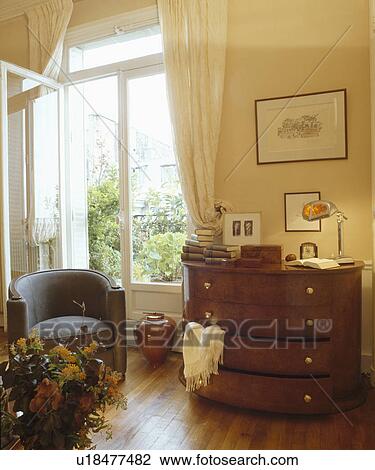 Small armchair and antique chest-of-drawers beside open French windows View Large Photo Image Stock Image - Small armchair and antique chest-of-drawers beside open French windows. Fotosearch