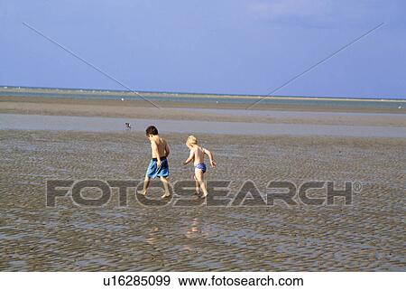Small boys walking across the sands at Holkham in Norfolk View Large Photo Image Stock Photo - Small boys walking across the sands at Holkham in Norfolk. Fotosearch