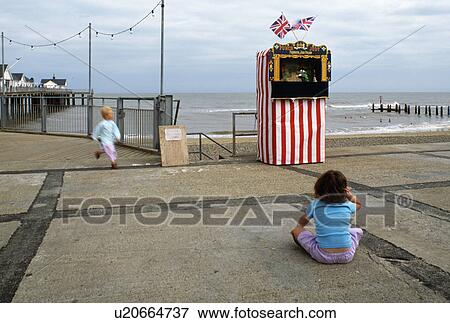 Stock Photo - Small girl in front of Punch & Judy Show at Southwold in Suffolk. Fotosearch