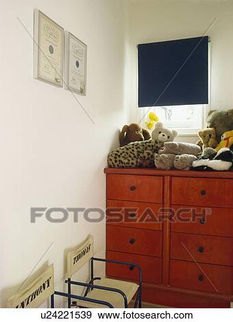 Soft toys on red chest-of-drawers in child's bedroom View Large Photo Image Stock Photo - Soft toys on red chest-of-drawers in child's bedroom. Fotosearch