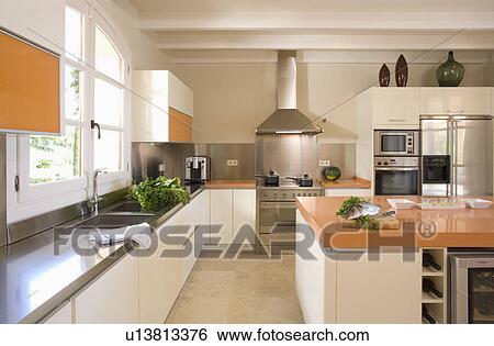 Stainless steel and white kitchen with large island unit for food preparation. View Large Photo Image Stock Photograph - Stainless steel and white kitchen with large island unit for food preparation.. Fotosearch