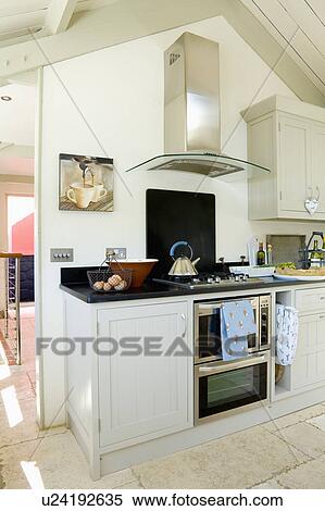 Stainless steel extractor above oven in modern kitchen with black granite worktop in converted coastal boathouse View Large Photo Image Stock Photography - Stainless steel extractor above oven in modern kitchen with black granite worktop in converted coastal boathouse. Fotosearch