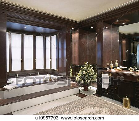 Stock Image - Steps up to bath in modern marble bathroom. Fotosearch