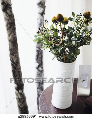 Still-Life of green foliage in white cylindrical vase View Large Photo Image Stock Image - Still-Life of green foliage in white cylindrical vase. Fotosearch