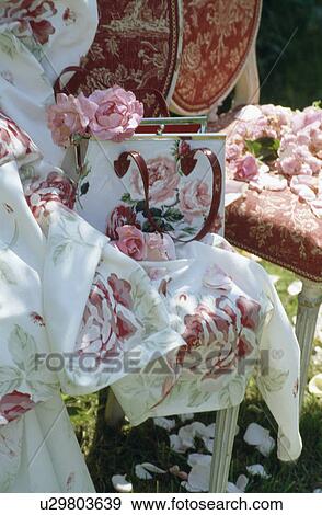 Stock Photo - Still-life of pink roses and rose-patterned handbag on rose patterned fabric. Fotosearch
