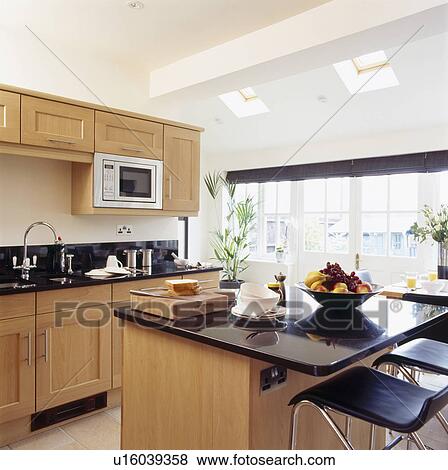 Pictures Of Stools At Granite Top Breakfast Bar On Island Unit In Picture Stools At Granite Top Breakfast Bar On Island Unit In Modern Kitchen Extension With