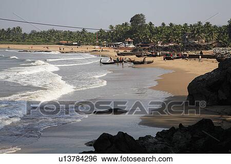 Stock Photograph - Surf rolling onto crescent shaped beach in India.. Fotosearch