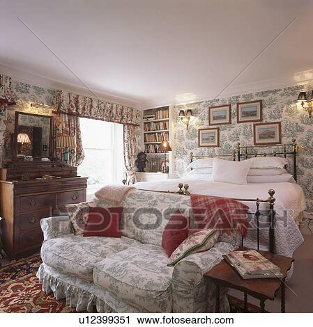 Toile De Jouy Sofa In Comfortable Bedroom With Wallpaper And Pictures On Walls Stock Image