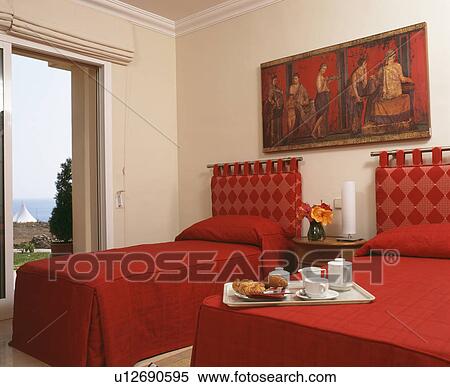 Twin beds with breakfast tray and red bedlinen in modern Spanish bedroom View Large Photo Image Stock Photography - Twin beds with breakfast tray and red bedlinen in modern Spanish bedroom. Fotosearch