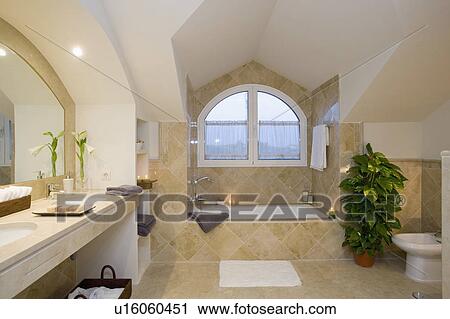 Stock Image - Unuual curved dormer window in attic bathroom. . Fotosearch
