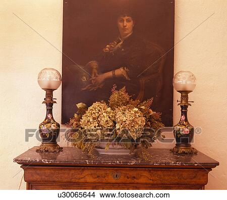 Victorian portrait above table with antique lamps and vase of dried hydrangeas View Large Photo Image Picture - Victorian portrait above table with antique lamps and vase of dried hydrangeas. Fotosearch