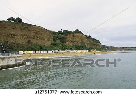 View across sea of row of beach huts against a sandy cliff at Shanklin on the Isle of Wight View Large Photo Image Stock Photo - View across sea of row of beach huts against a sandy cliff at Shanklin on the Isle of Wight. Fotosearch