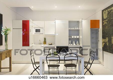 Well lit minimalist kitchen with cupboard doors open to show contents and table and chairs. View Large Photo Image Stock Image - Well lit minimalist kitchen with cupboard doors open to show contents and table and chairs.. Fotosearch