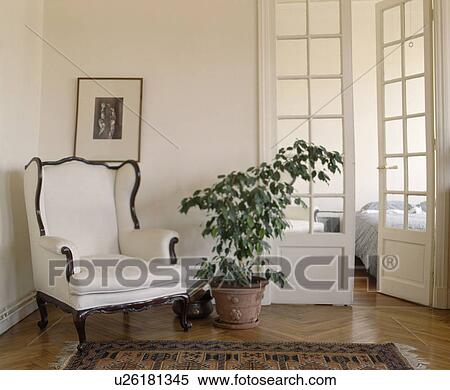 White armchair and green houseplant in white townhouse hall View Large Photo Image Stock Photography - White armchair and green houseplant in white townhouse hall. Fotosearch
