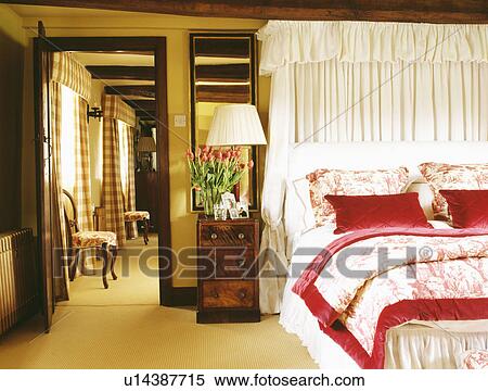 White drapes above bed with Toile-de-Jouy bedlinen and red silk cushions View Large Photo Image Stock Photography - White drapes above bed with Toile-de-Jouy bedlinen and red silk cushions. Fotosearch