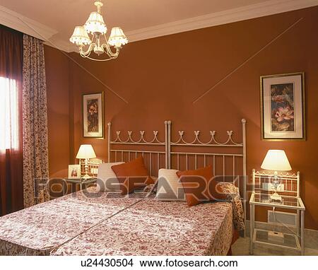 Picture - White metal twin beds in terracotta bedroom. Fotosearch