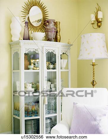 White painted glass-front cupboard in pastel yellow living room View Large Photo Image Stock Photograph - White painted glass-front cupboard in pastel yellow living room. Fotosearch