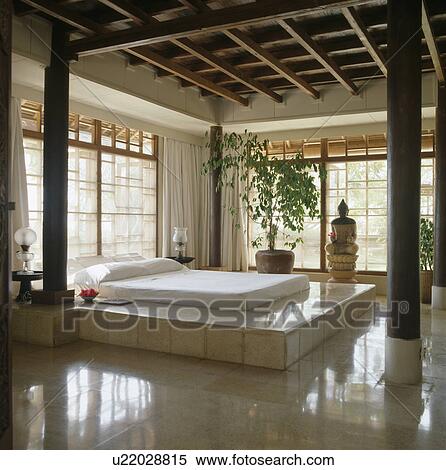 White tiled raised bed in Balinese bedroom with timbered ceiling View Large Photo Image Stock Photography - White tiled raised bed in Balinese bedroom with timbered ceiling. Fotosearch